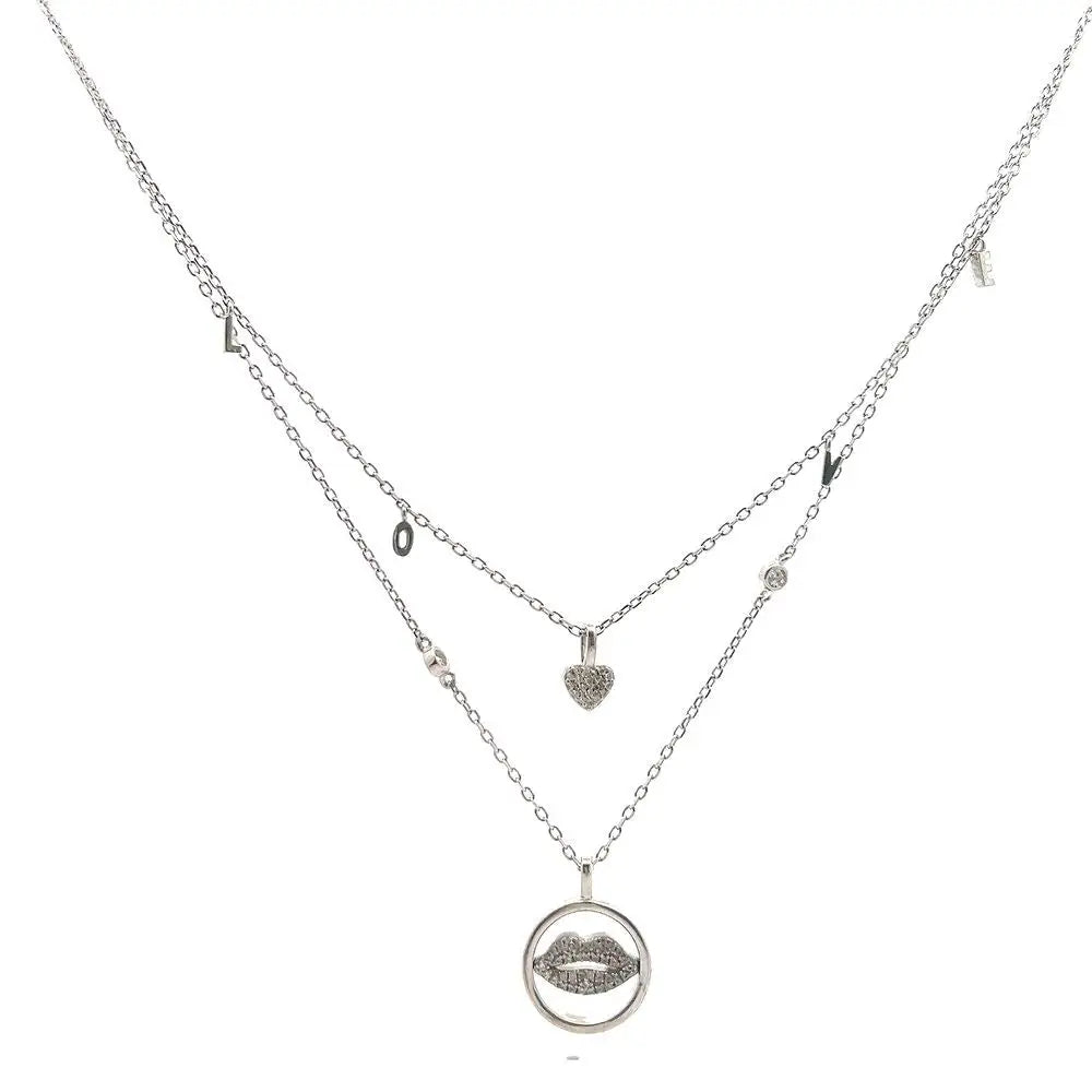 A silver-colored necklace with two layers, featuring a heart and a lip charm, and small dangling charms.