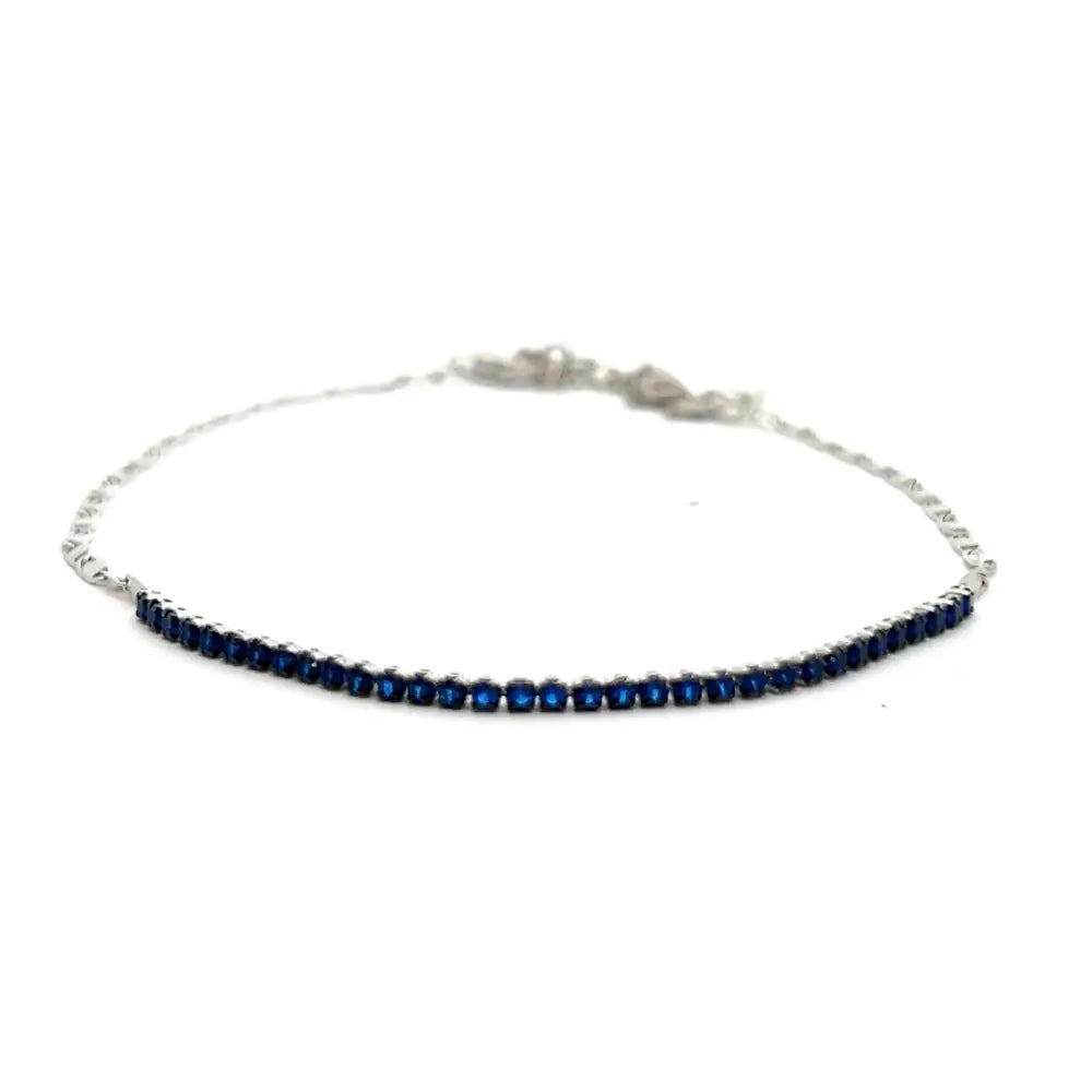 A silver-toned chain anklet adorned with deep blue zirconia stones, displayed against a white background.