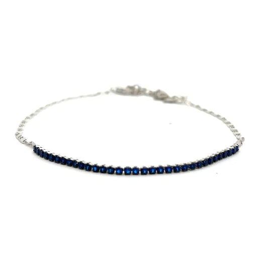 A silver-toned chain anklet adorned with deep blue zirconia stones, displayed against a white background.