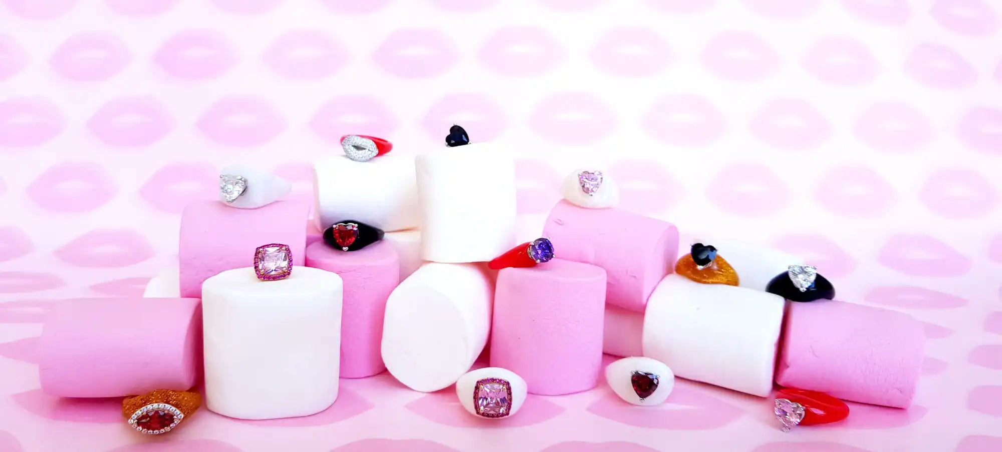 A collection of colorful rings displayed on pink and white marshmallows.