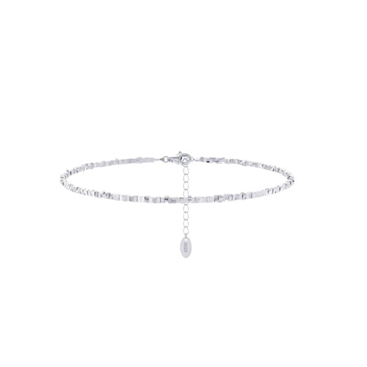 A silver-colored anklet with square-cut links and a small dangling charm, displayed against a white background.