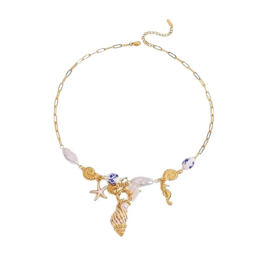 Gold necklace with seashell and starfish charms on a white background