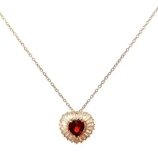 A gold necklace featuring a radiant heart-shaped stone at its center, with a dazzling halo of baguette and round-cut accents.