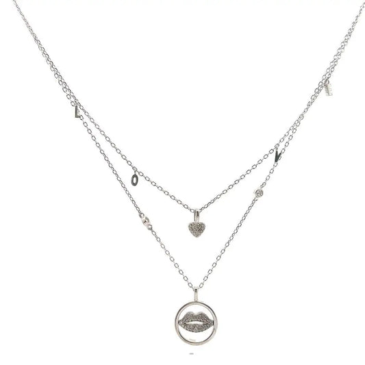 A silver-colored necklace with two layers, featuring a heart and a lip charm, and small dangling charms.