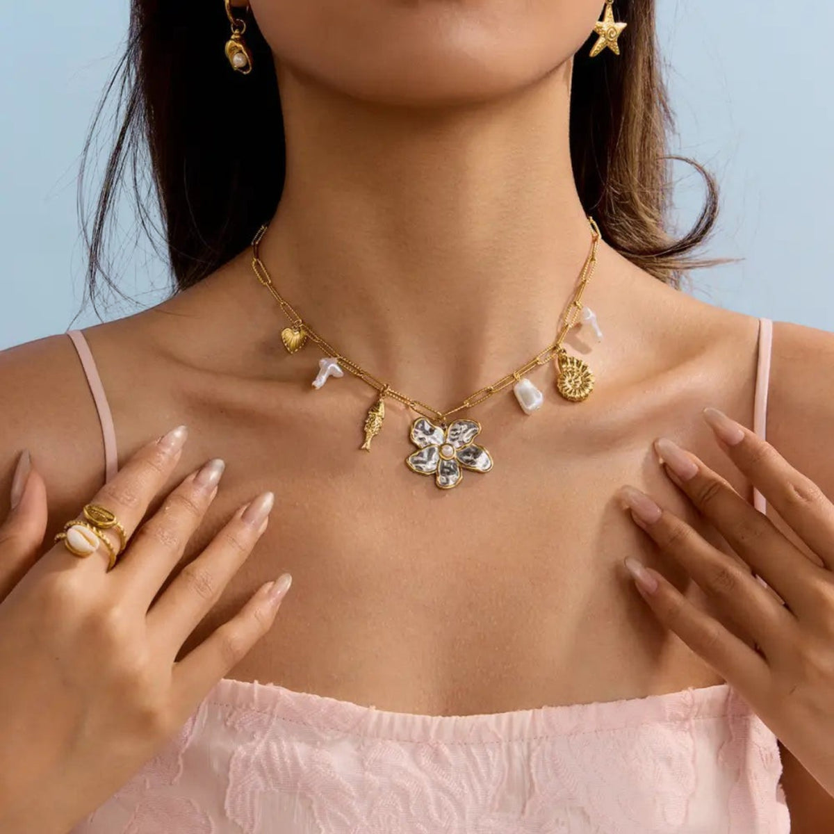 Scandal Kiss gold flower charm necklace with mixed organic drops and link chain worn on a model