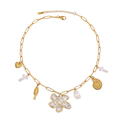 Scandal Kiss gold flower charm necklace featuring a statement floral pendant, mixed charms, and organic stone drops.