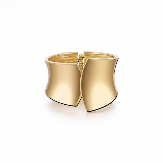 Scandal Kiss wide gold-plated cuff bracelet with a smooth sculpted silhouette and high-polish finish.