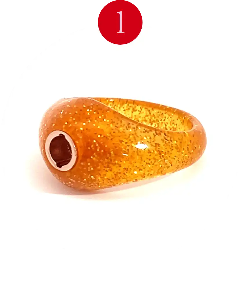 Sparkly orange resin ring with a dark brown and silver-toned bead on the side.