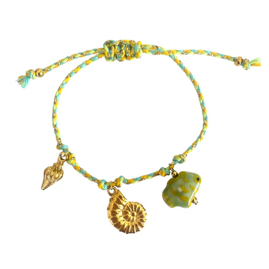 Bracelet with shell and fish charms on a white background