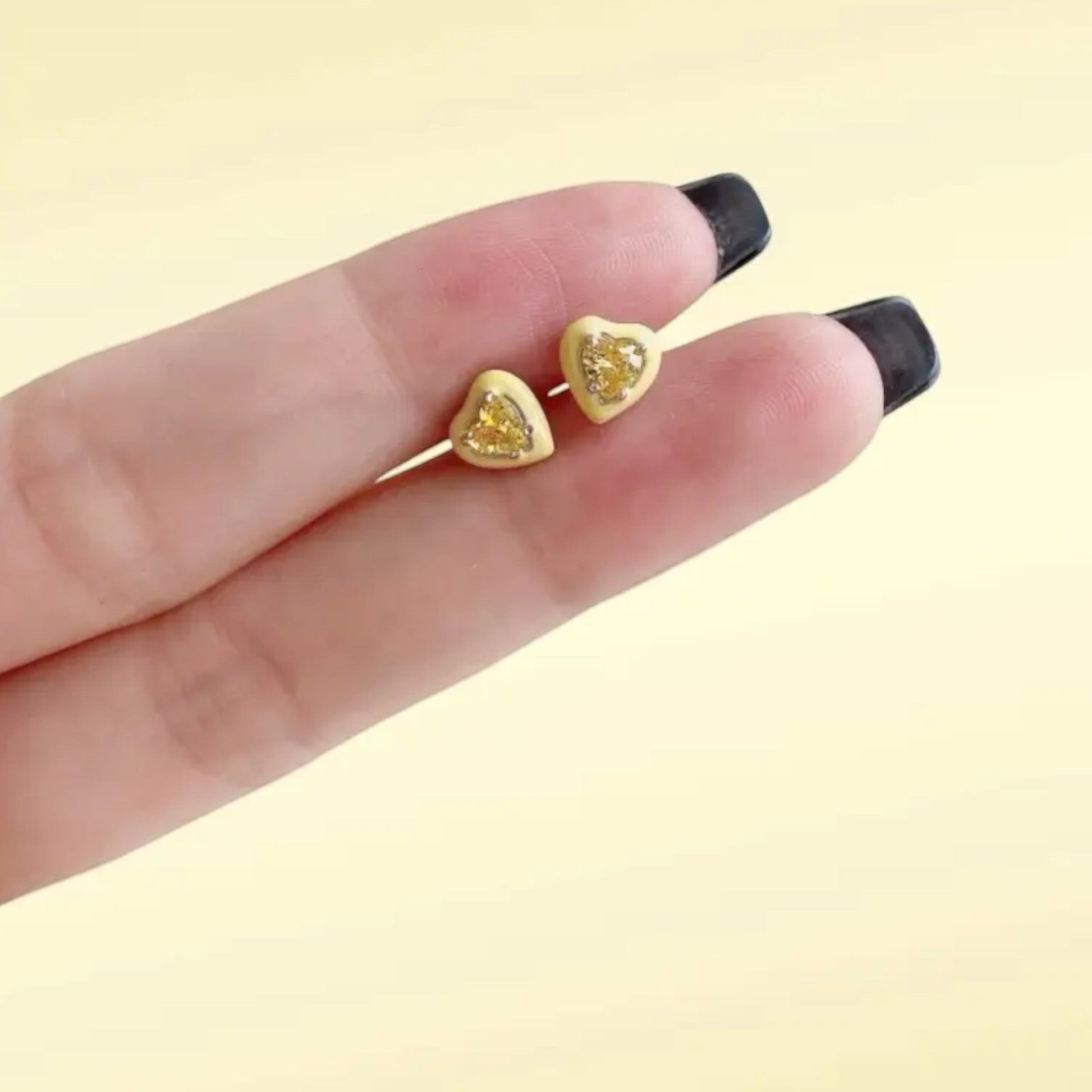 Yellow enamel heart stud earrings in gold plated sterling silver with a glossy finish